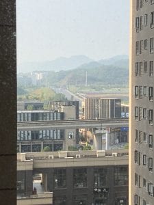 picture looking out of a window at many buildings and mountains in the background